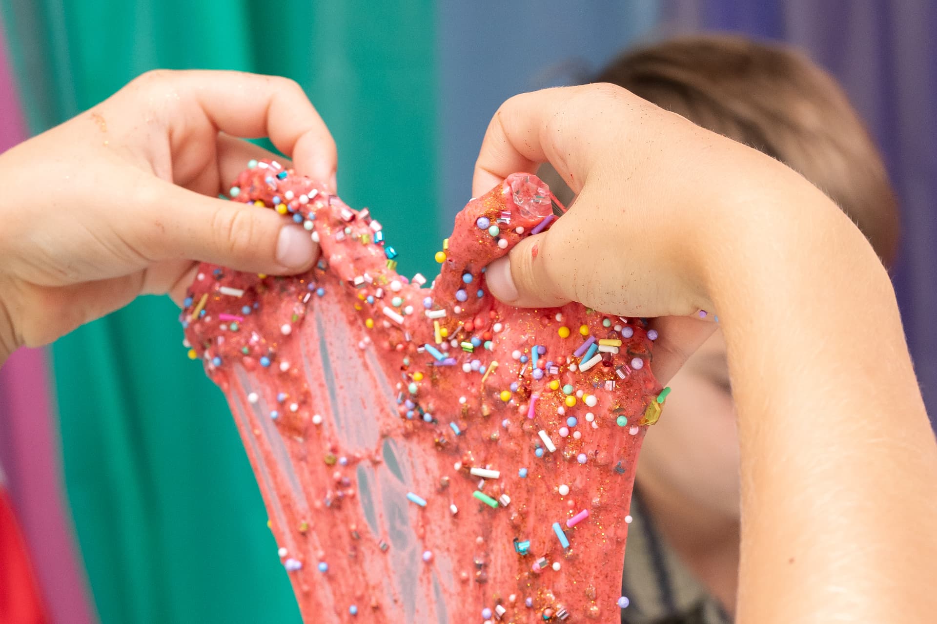 Stretching pink sprinkle-covered slime close up