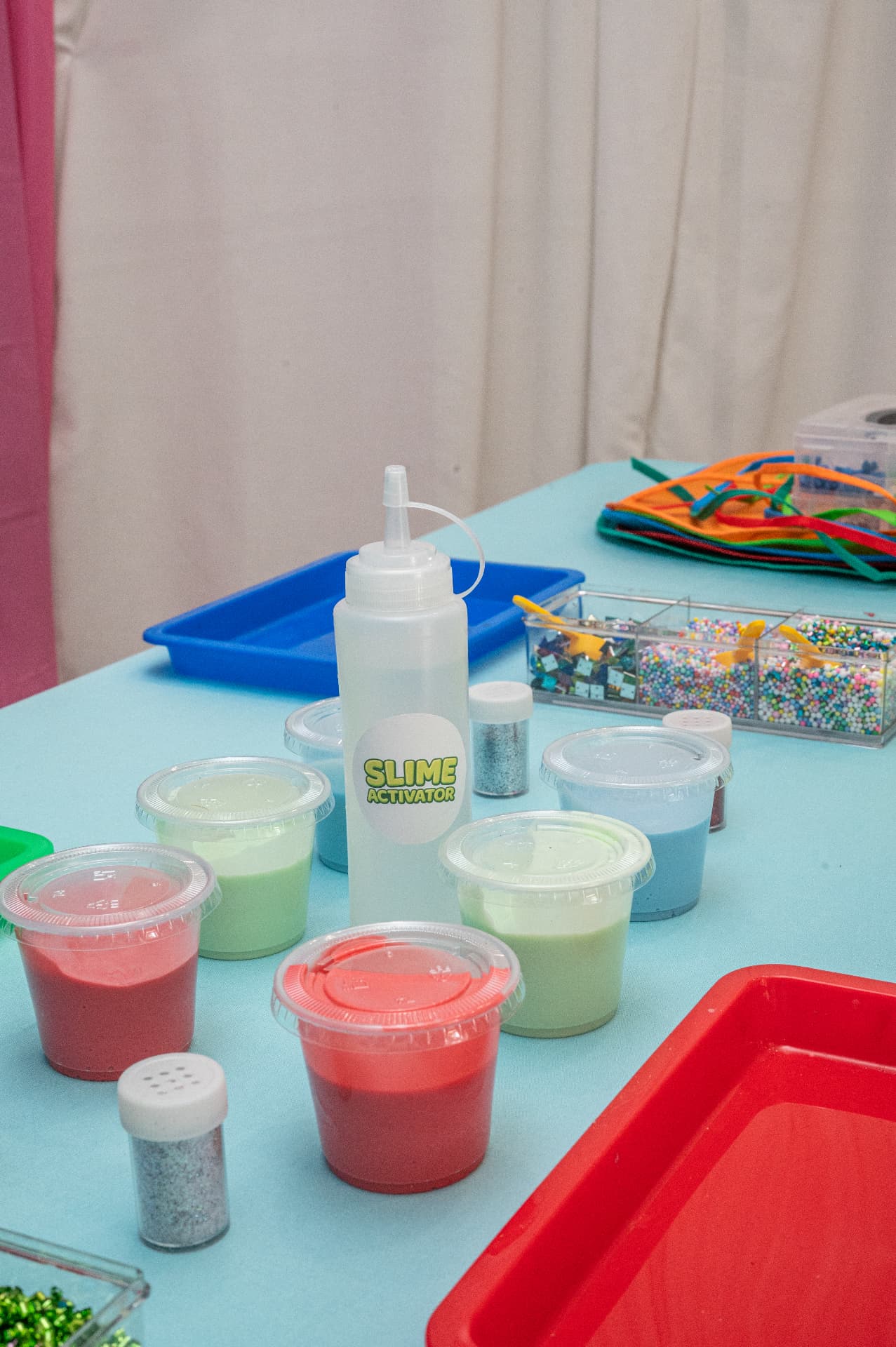 Slime activator, colorful slime cups and mix-ins ready for guests