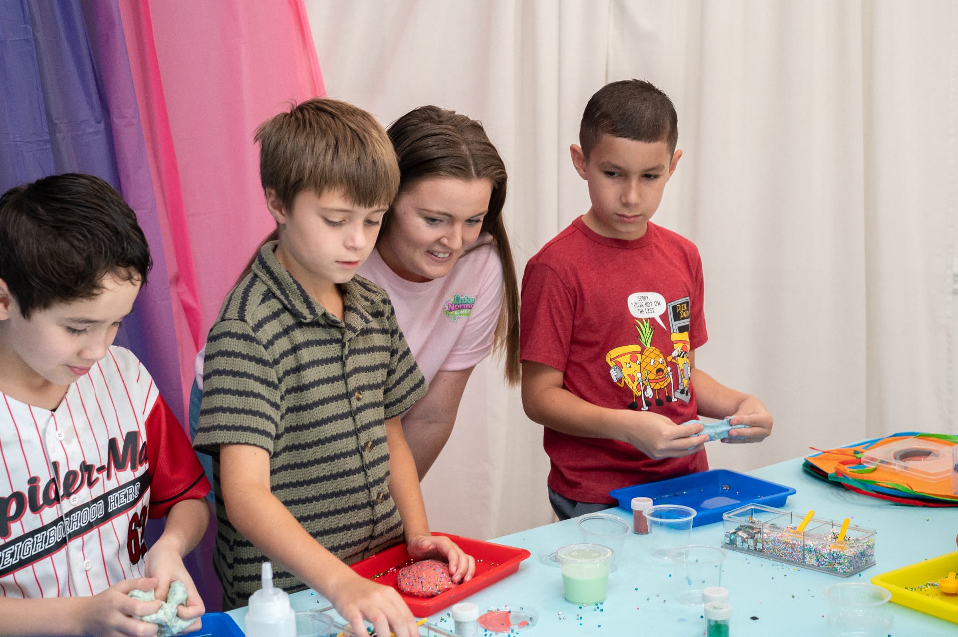 Slime artist guiding kids as they make their own slime