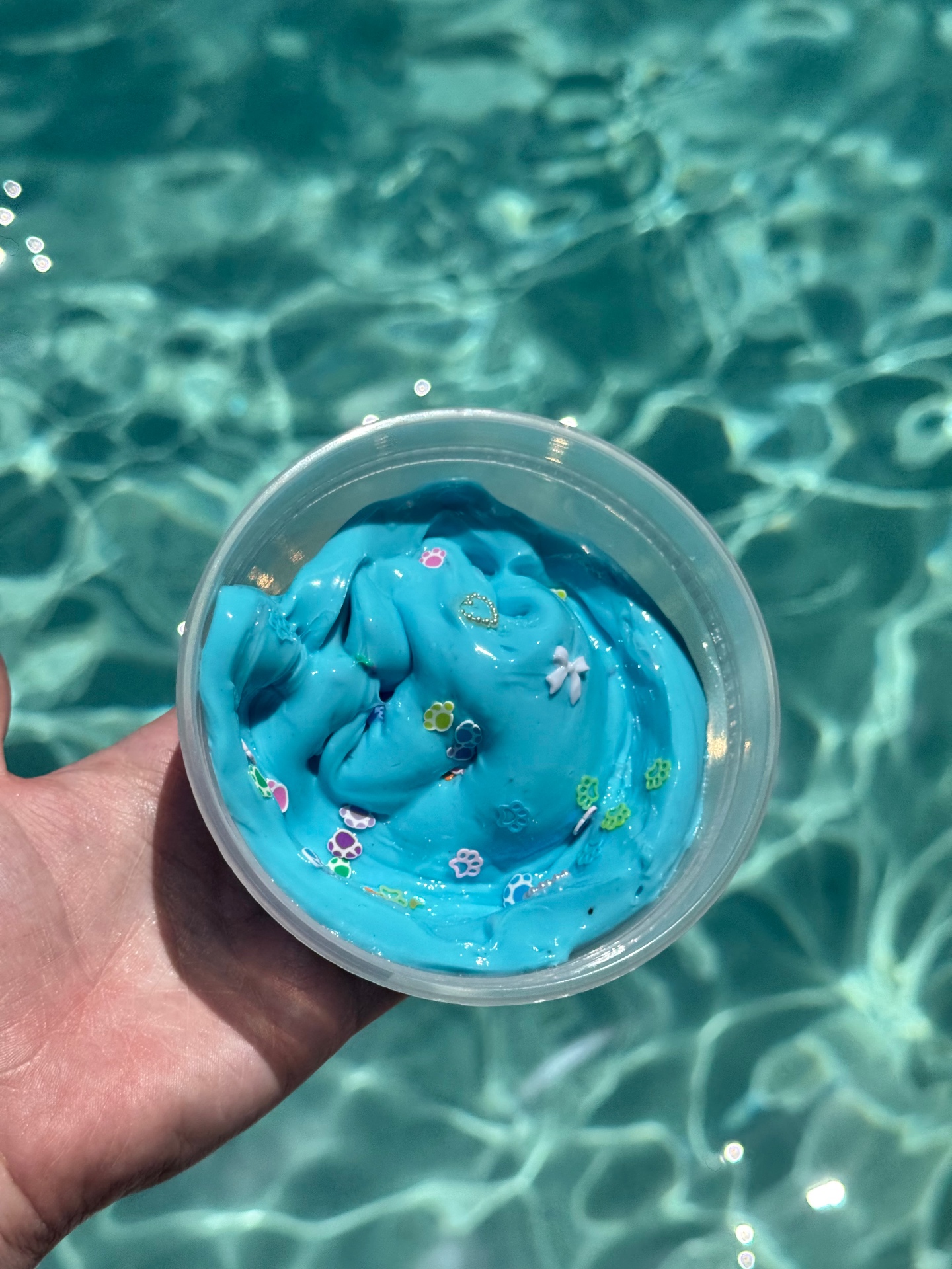 Ocean blue cloud slime with paw print charms in a clear jar