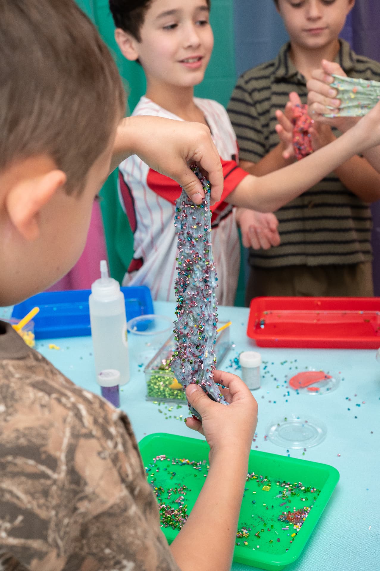 Kids showing off stretchy glitter slime creations